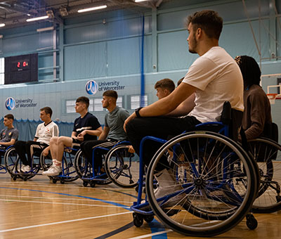 A group of students are getting ready to play wheelchair basketball