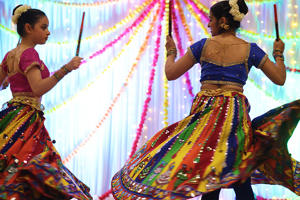 Two girls are brightly dressed and dancing at the diwali celebrations