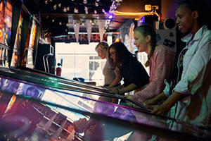 Students playing arcade games in a shop