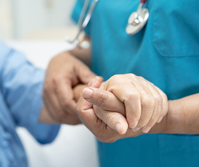 Close up of nurse holding a patient's hand