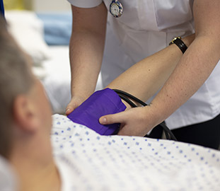 Nurse fixing a blood pressure sleeve to an arm