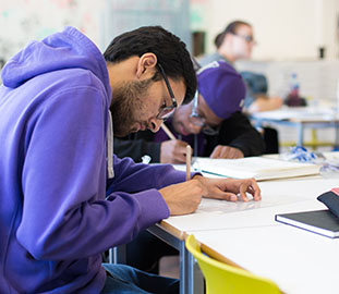 students writing at a desk
